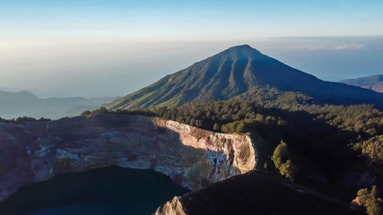 Drone shot of volcano Kelimutu's crater lakes in Moni, Flores, Indonesia. The lake has a dark shade of blue. In the back there is another volcano. Natural phenomenon