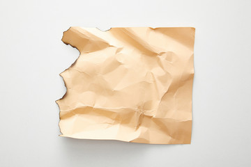 top view of empty crumpled and burnt beige vintage paper on white background