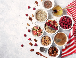 Healthy breakfast, top view. Oatmeal porridge with raspberries, figs, chia seeds, flax seeds, almonds and pecans, honey and coffee.