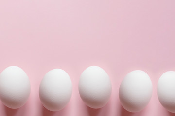 Easter eggs border on pastel pink background