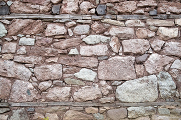 Old stone wall with wooden beams closeup