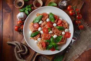 Italian Colorful Pasta dish or Spaghetti Napolitana with cherry tomatoes, vegan mozzarella and basil 