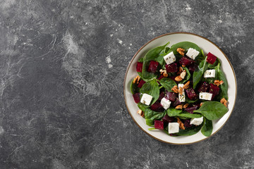 Fototapeta na wymiar Vegetarian beetroot carpaccio salads with spinach, basil, olive oil, goat cheese, walnuts, texture background. Top view, space. Healthy eating.