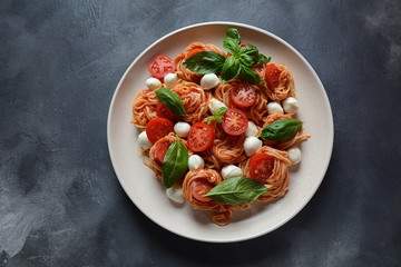 Italian Colorful Pasta dish or Spaghetti Napolitana with cherry tomatoes, vegan mozzarella and basil 