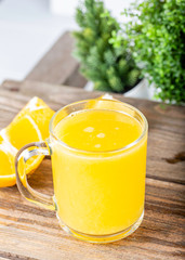 glass of fresh orange juice with fresh fruits on wooden table
