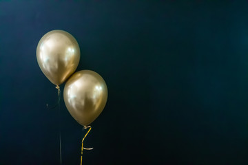 two golden balloons on a dark background. Holiday Concept, Postcard