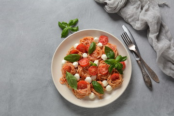 Italian Colorful Pasta dish or Spaghetti Napolitana with cherry tomatoes, vegan mozzarella and basil 