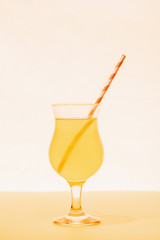 yellow cocktail with straw on bright background