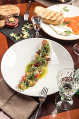 octopus salad with potatoes and cherry tomatoes on wooden table at restaurant