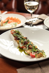 octopus salad with potatoes and cherry tomatoes on wooden table at restaurant