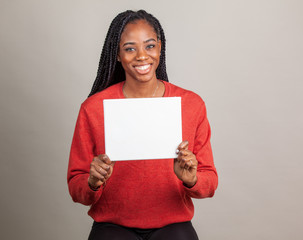 African American woman with blue eyes holding a sign with room for copy.