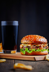 Delicious Burger on wooden table and dark background
