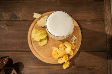 Beer glass with beer and hot smoked fish close-up. Beer mug with beer and fish on a dark background and copy space.