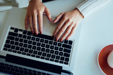 Fototapeta na wymiar Close up of female hands on laptop typing 