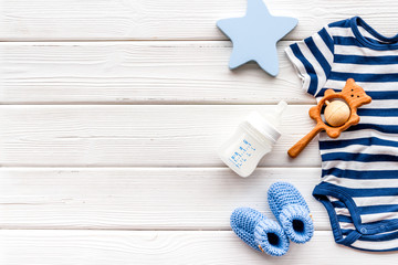 Baby background - blue color. Clothes and accessories for newborn boy on white wooden table top-down frame copy space