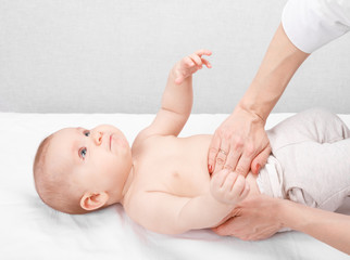 Child check up - doctor examining stomach of little baby performing manual palpation