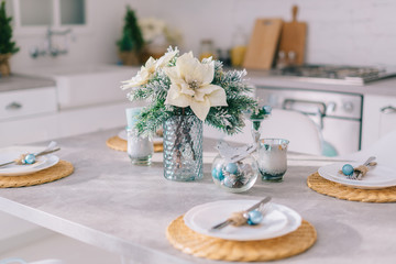 Festive Christmas table setting in a bright cozy kitchen, close up