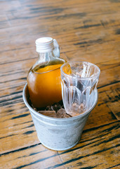 Cold brew tea bottle in ice bucket with glass
