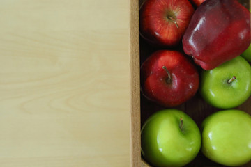 red and green apple fruit in harvest wood basket put on wooden table
