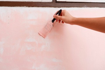 Painter paints pink wall