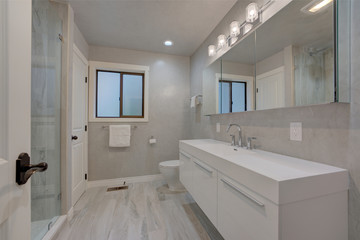 Fototapeta na wymiar Modern white and grey bathroom with walk in glass shower