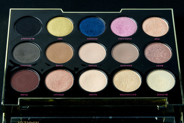Make-up colorful eyeshadow palettes isolated on black background. View from above. 