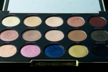 Make-up colorful eyeshadow palettes isolated on black background. View from above. 