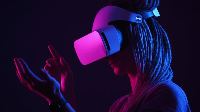 lady in modern virtual reality glasses looks at hands
