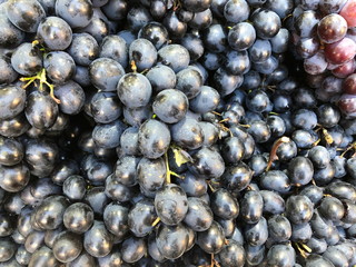 Healthy fruits black wine grapes background in a supermarket