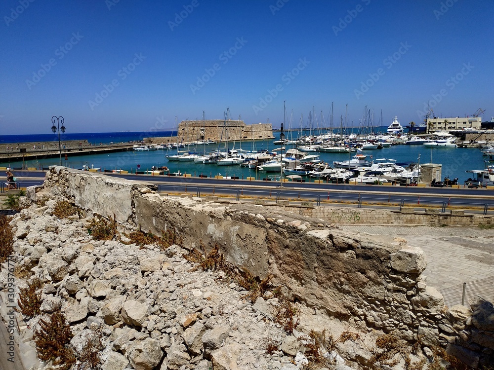 Wall mural HERAKLION, GREECE - JUNE 27, 2019: casual view on the city streets with pedestrian and visitor at summer sun