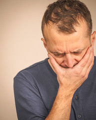 Sad worried man covering his mouth