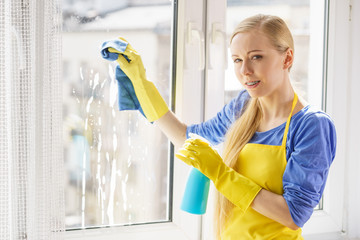 Woman cleaning window at home