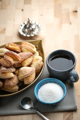 Homemade cookies with cottage cheese in a ceramic bowl and copper coffee cezve on a wooden background..
