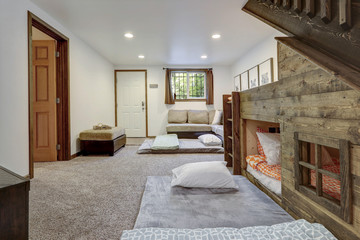 Living room with build in bunk bed under staircase and extra sleeping spaces.