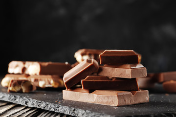 Hazelnut,  and almond, milk and dark chocolate pieces tower  on dark background close-up