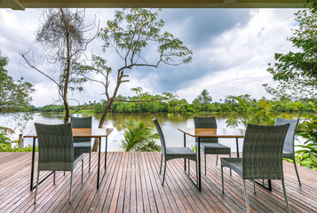 Obraz premium Empty tables and chairs on the riverside with outdoor.
