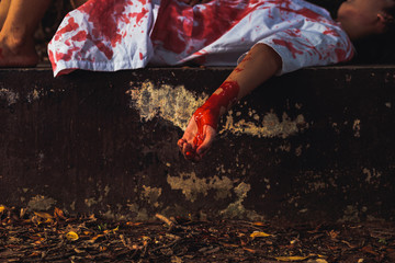 Murdered women's hand lying on the ground in the middle of the forest. © Charnchai saeheng