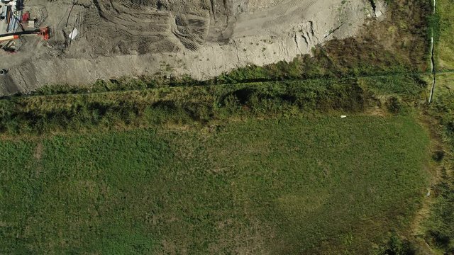 Top down aerial view of machines moving earth on a construction site.