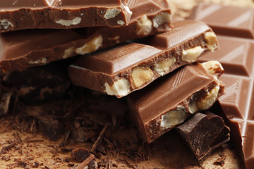 Different pieces of dark chocolate close-up. Top view. Place for text.