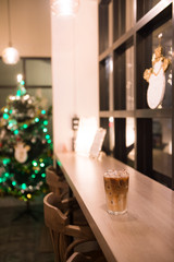 ice latte coffee in plastic cup put on wooden table, christmas theme background