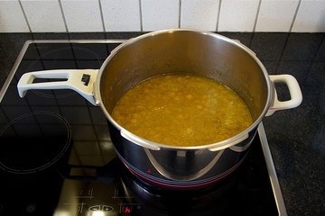 Chickpea homemade fresh cooked soup into pressure cooker at home kitchen ready to eat. Top view, soft focus at the foreground