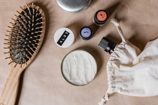 Flatlay de produits de beaut&eacute; naturels comme un d&eacute;odorant solide, de l'aloe vera, une brosse en bois et des huiles essentielles