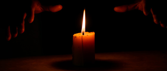 Candlelight and the magician's hand in the dark, Divine magic & occultism concept.