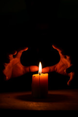 Candlelight and the magician's hand in the dark, Divine magic & occultism concept.