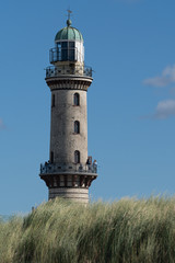 lighthouse on an island surrounded by tall grass 