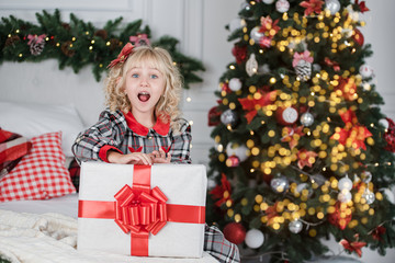 Obraz na płótnie Canvas Happy excited girl child holding christmas gift box.