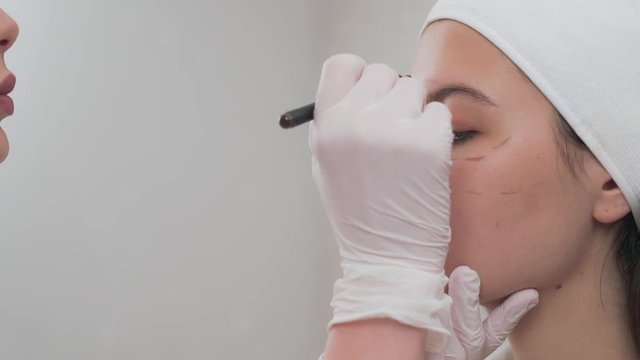 Side view of girl with perforation lines on face in clinic