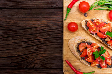Fresh tasty bruschetta with truffle sauce, parsley and tomates. Top view