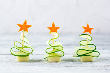 Creative set christmas trees of cucumber, cheese and star of carrot. Funny kids food for new year party with copy space