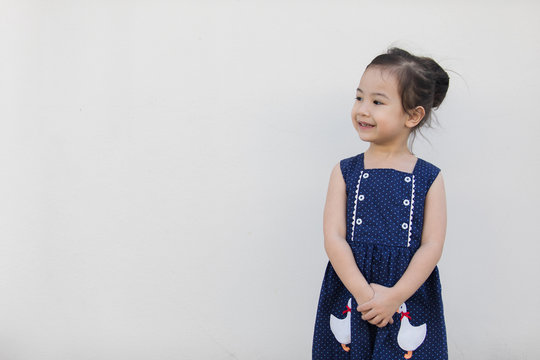 A Cute Asian Girl With A Bright Blue Dress, Contrasting With The Skin Color And White Background That Everyone Will Fall In Love.